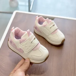 Close-up of white and pink toddler sneakers with velcro closure and fashion embroidery