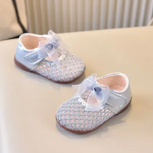 Détail de chaussures de princesse en mesh argenté avec nœud en tulle et bride velcro