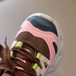 Détail de la maille marron respirante et du cuir synthétique rose des baskets enfant