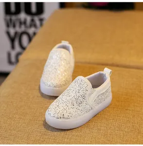 Close-up of sparkling silver sequin slip-on shoes with durable white rubber soles