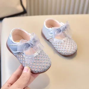 Détail des chaussures princesse pour bébé avec maille bleue et nœud en organza