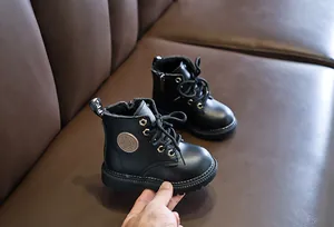 Detail view of children's leather Martin boots featuring a side zipper and textured finish