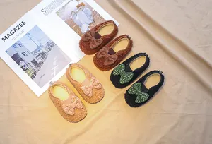 Close-up of plush fleece toddler loafers with polka dot bows in multiple colors