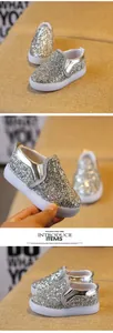 Close-up of shiny silver sequin kids slip-on shoes with white rubber sole and elastic bands
