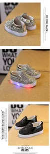 Close-up of sparkling sequin kids sneakers with colorful LED light-up soles
