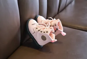 Close-up of pink leather boots featuring plush warm lining and side zipper detail