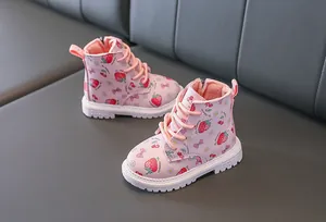 Close-up of pink toddler boots with strawberry prints and a thick non-slip white sole