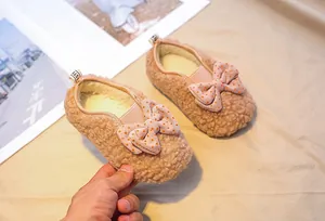 Close-up of girls teddy fleece loafers featuring a pink polka dot bow and plush lining