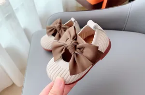 Close-up of knit baby princess shoes with large bow and soft non-slip rubber soles
