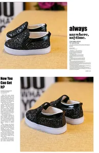 Close-up of black glitter material and glossy leather trim on kids LED slip-on shoes