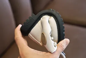 Detail showing high flexibility of the white leather kid boot with a bendable rubber sole