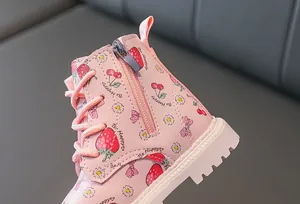 Detail view of pink leather boots featuring strawberry prints and side zipper closure