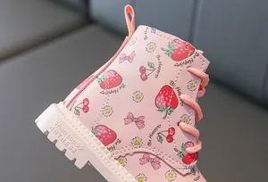 Detail of pink toddler boots featuring strawberry prints and thick rubber soles