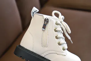 Detail view of cream white leather kids boots with side zipper and sturdy rubber sole