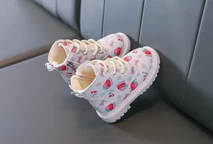 Detail of warm plush lining and strawberry patterns on white girls' boots