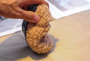 Close-up of flexible soft sole being bent to show the comfort of toddler lamb wool shoes