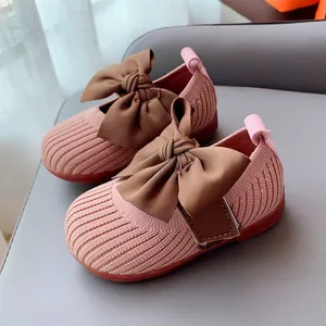 Pink knit baby girl shoes with large brown bow and durable non-slip rubber sole