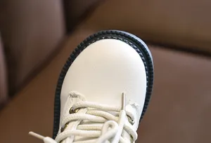 Close-up of cream white children boots with durable anti-slip rubber soles and soft laces