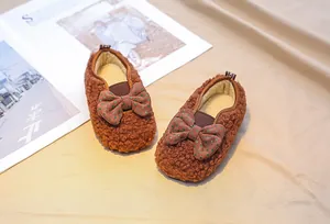 Detail of toddler lamb wool shoes featuring brown polka dot bow and plush inner lining