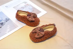 Detail of warm brown sherpa baby shoes with polka dot bow and plush fleece lining