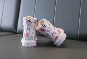 Close-up of strawberry floral pattern and plush lining on girls white boots