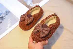 Detailed shot of brown plush toddler shoes with polka dot bow and warm fleece lining
