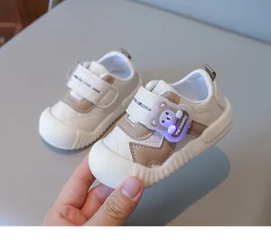 Detail of baby walking shoes with LED bear decor and soft non-slip rubber soles