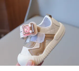 Detail view of baby walking shoe with quilt pattern and light-up bear charm