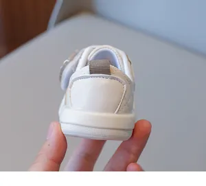 Detail of white leather baby shoes with quilted stitching and anti-slip rubber sole