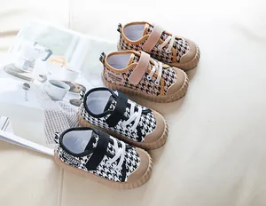 Detail of children canvas shoes with houndstooth pattern and rubber toe cap protection