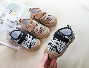 Detailed view of kids' houndstooth canvas shoes with non-slip rubber toe caps