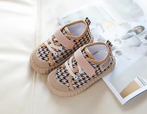 Detail of kids canvas shoes with houndstooth pattern and pink hook-and-loop closure