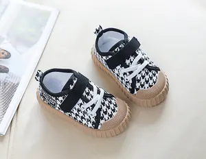 Detailed macro view of toddler canvas shoes featuring houndstooth pattern and gum rubber soles