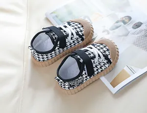 Detail of kids canvas shoes featuring houndstooth pattern and velcro strap closure