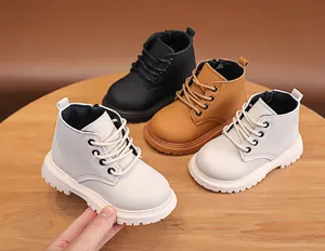 Close-up of kids leather boots in white beige and black with non-slip thick soles