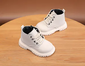 Detail of off-white children's boots with non-slip rubber soles and side zippers