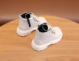 Detail of cream white faux leather kids boots with thick non-slip rubber soles and zipper