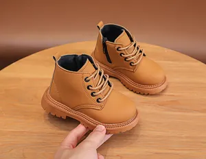 Detailed view of children's brown leather boots with side zipper and rugged rubber sole
