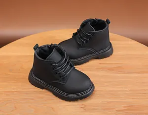 Detail of kids black leather combat boots with lace-up front and non-slip rubber soles