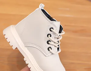 Detail shot of cream kids boots with matte synthetic leather and non-slip lug sole