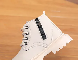 Detailed close-up of side zipper and durable thick sole on cream kids combat boots