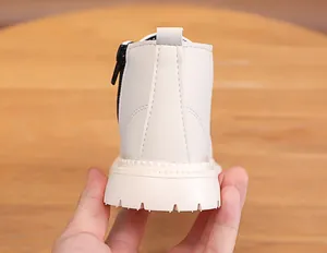 Detail view of cream toddler boots featuring premium double stitching and black side zippers