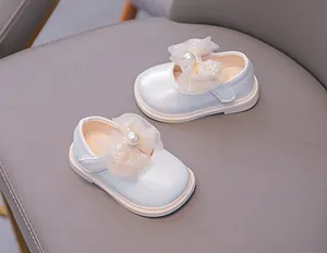 Detail of white Mary Jane shoes with mesh bow and pearl embellishment for toddler girls