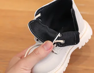 Detail view of white children's Martin boots with side zipper and thick non-slip rubber sole