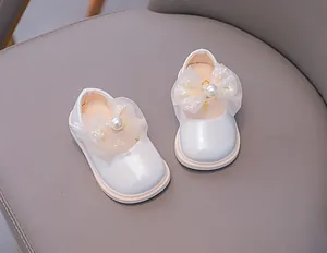 Close-up of a baby girl Mary Jane shoe with a pearl bow and soft pink rubber sole