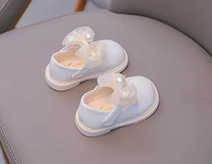 Detail of white Mary Jane shoe with layered mesh bow, pearls and sequins decoration