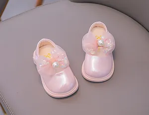Close-up of pink toddler princess shoes with delicate mesh bow and pearl details