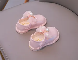 Detail of pink Mary Jane baby shoes with mesh bow, faux pearl, and Velcro strap