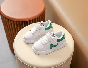 Détail de baskets blanches pour bébés avec broderie ours vert et velcro pratique