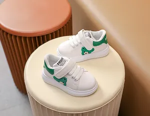 Détail de baskets blanches pour bébés avec velcro et motif d'ours vert mignon